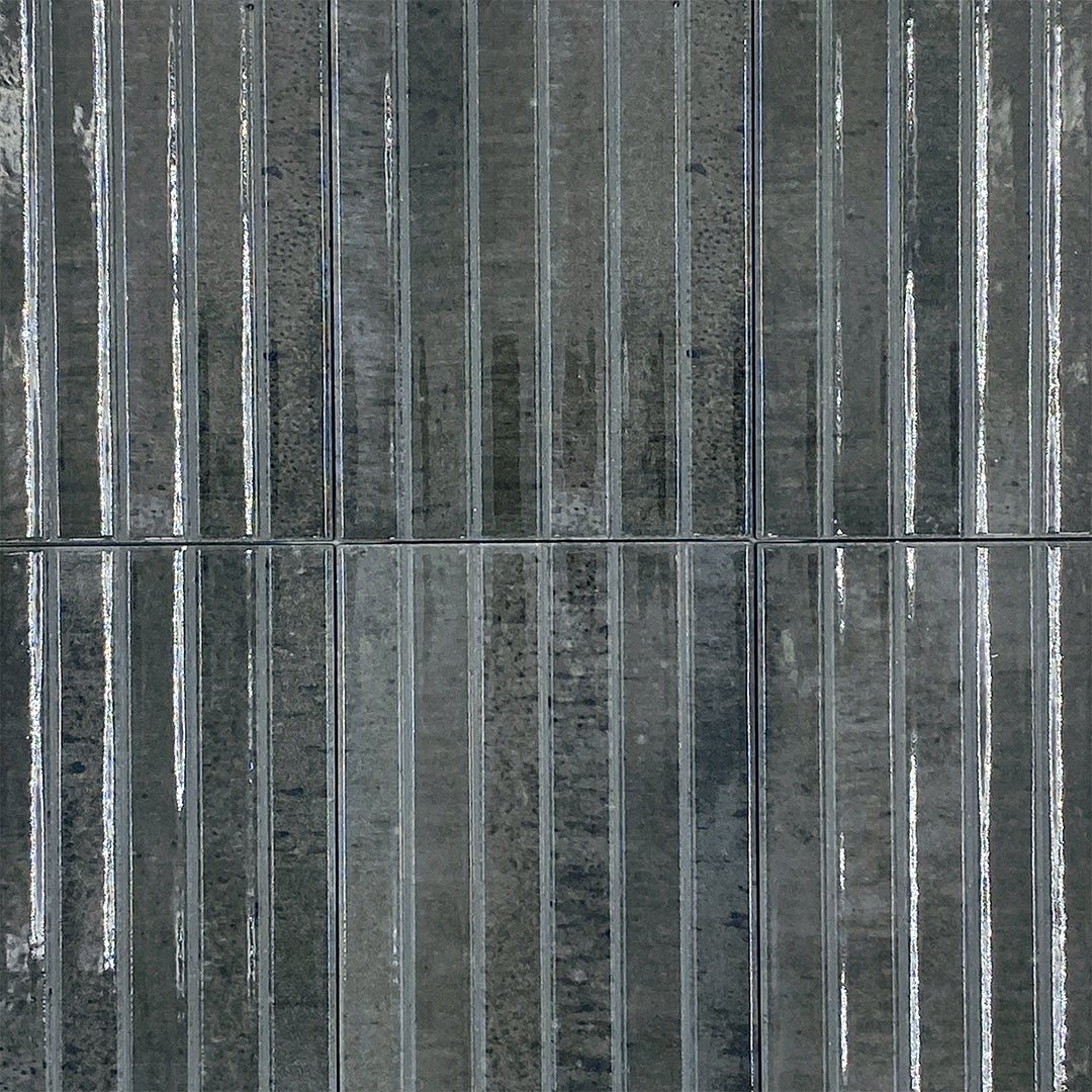 Ariel view of a group of 5x10 panel tiles in glossy black, the tile has a 3D linear faux grout line kitkat look. 