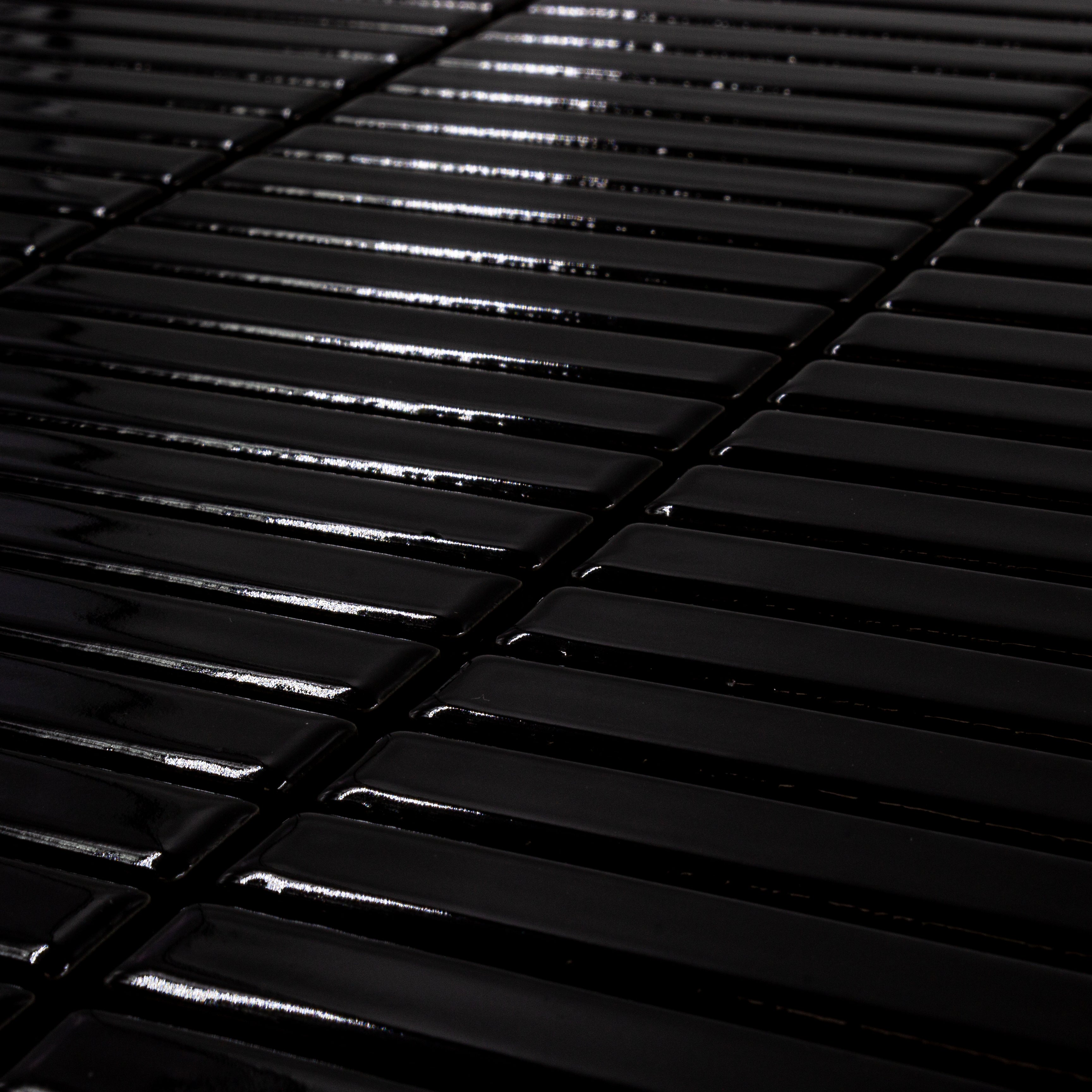 Angled close up view of a single sheet of mini kitkat stacked mosaic tiles in rich black glossy. The sizing is 3/8' x 3-5/8