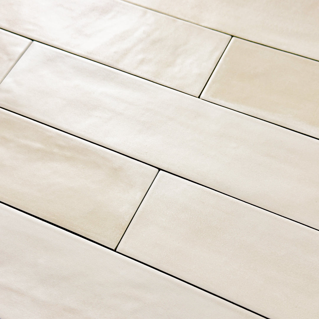 Close up detailed view of a 2x9 matte subway tile in a soft beige shade with subtle texture.