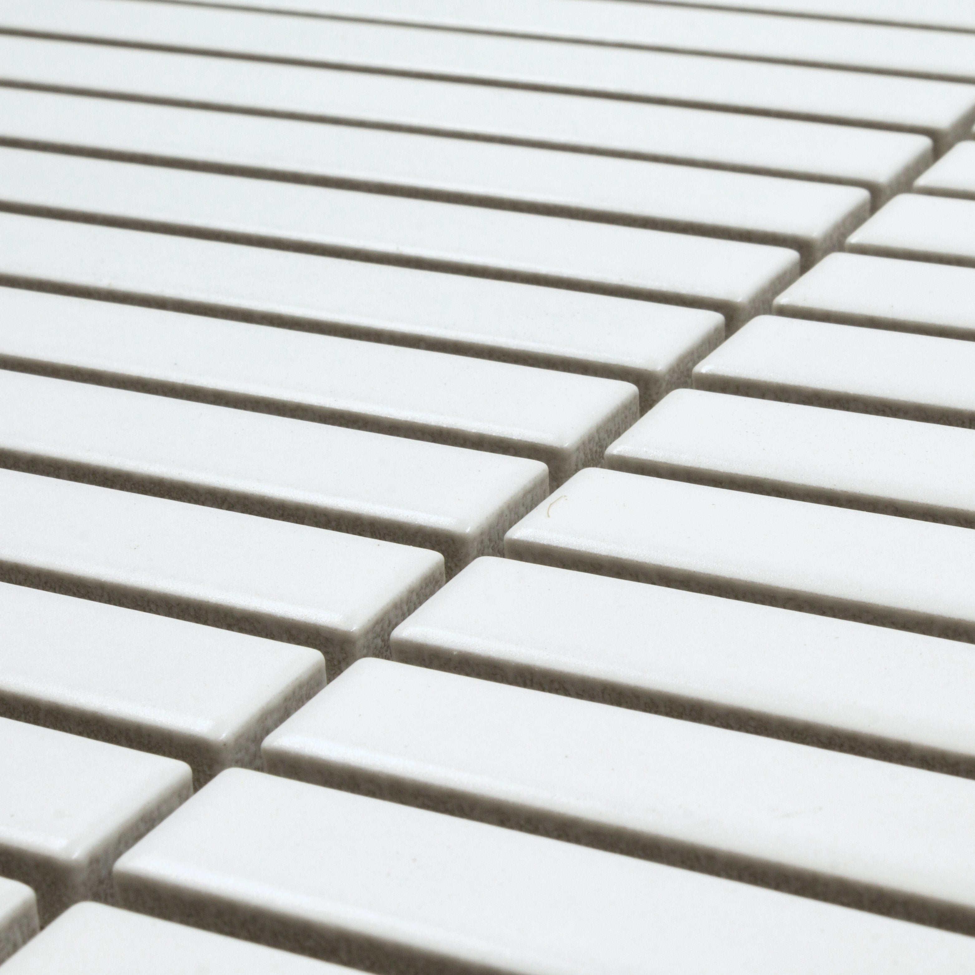 Angled close up view of a single sheet of kitkat stacked mosaic tiles in matte bright white. The sizing is 5/8' x 5-5/8