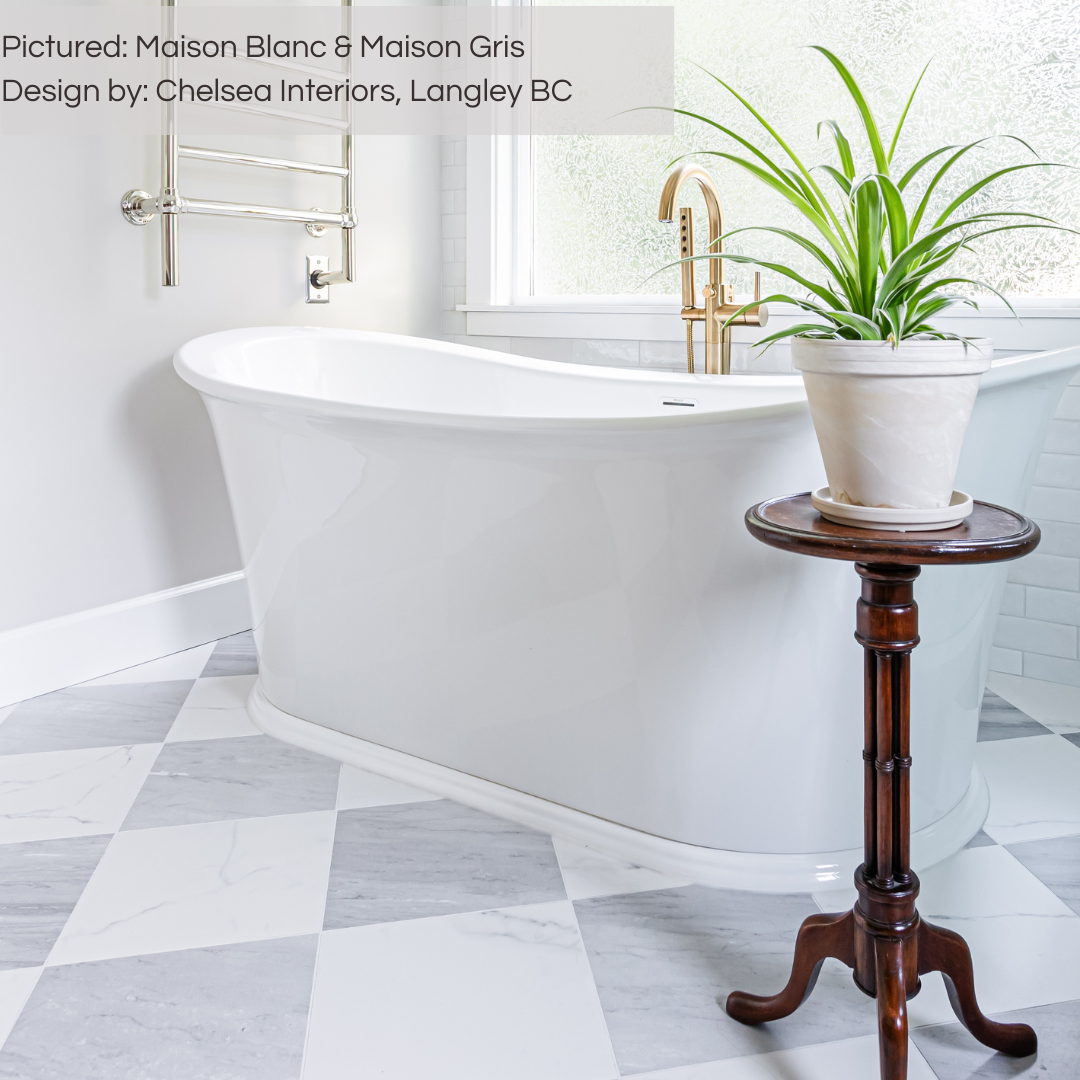 A spa like white bathtub with marble look grey and white porcelain tiles underneath on floor laid out in a diamond checker pattern. there are rich wood accents and gold fixtures. 