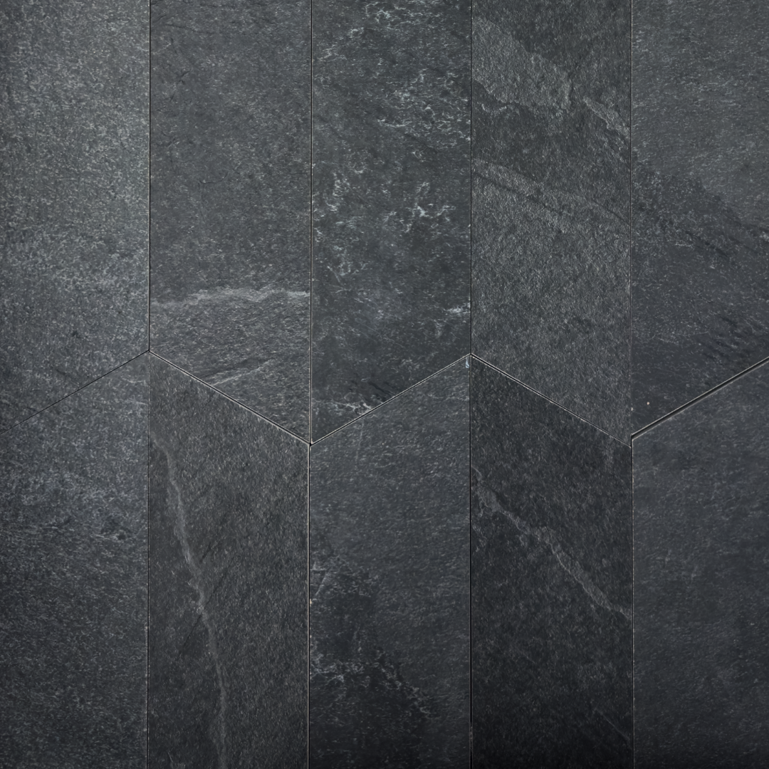 Ariel view of a group of black slate look 4x20 chevron tiles to show the shape, colour and pattern. 